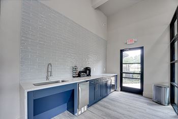 Kitchenette with blue cabinets and white countertops